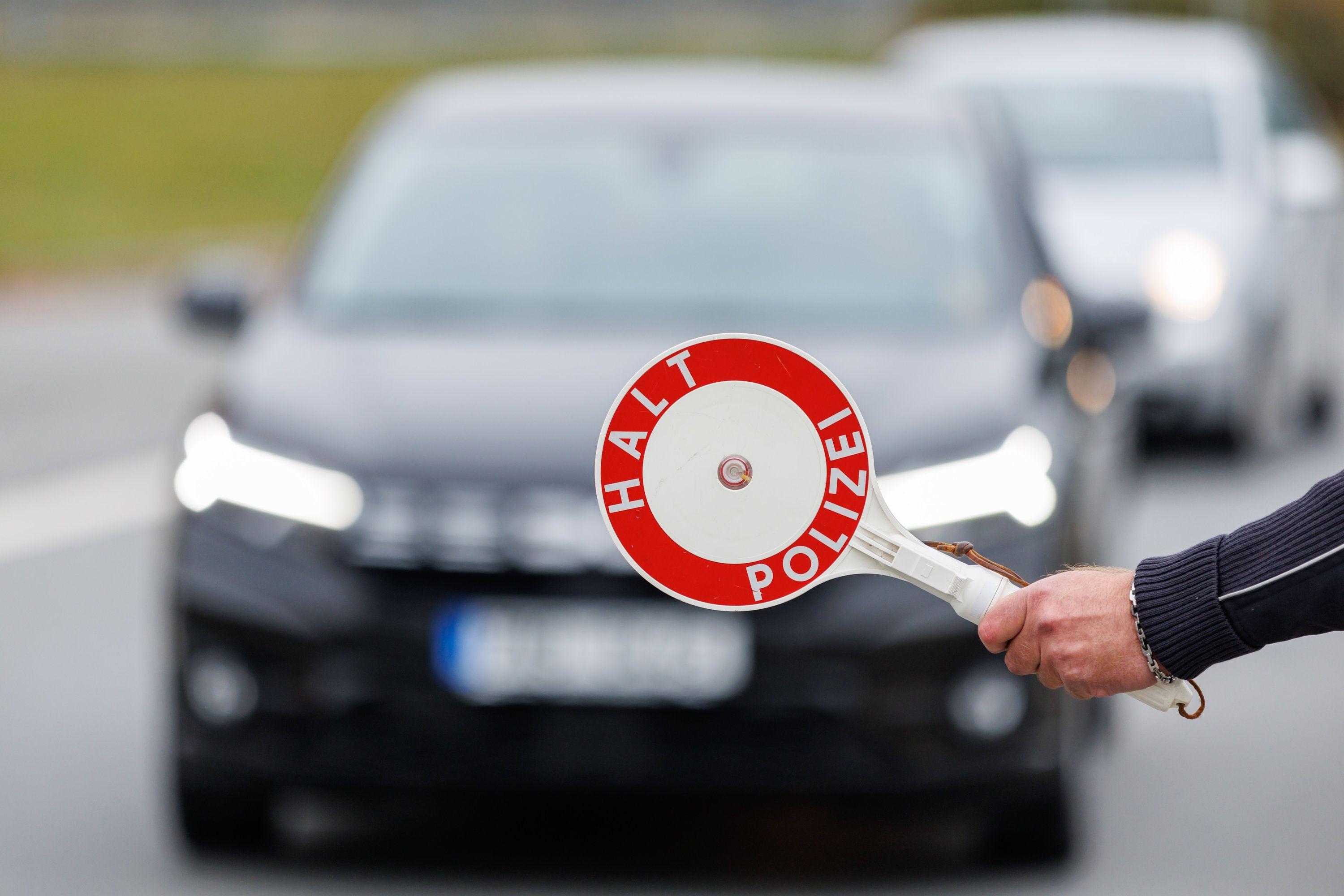 Ein Polizist hält ein Fahrzeug zur Kontrolle an