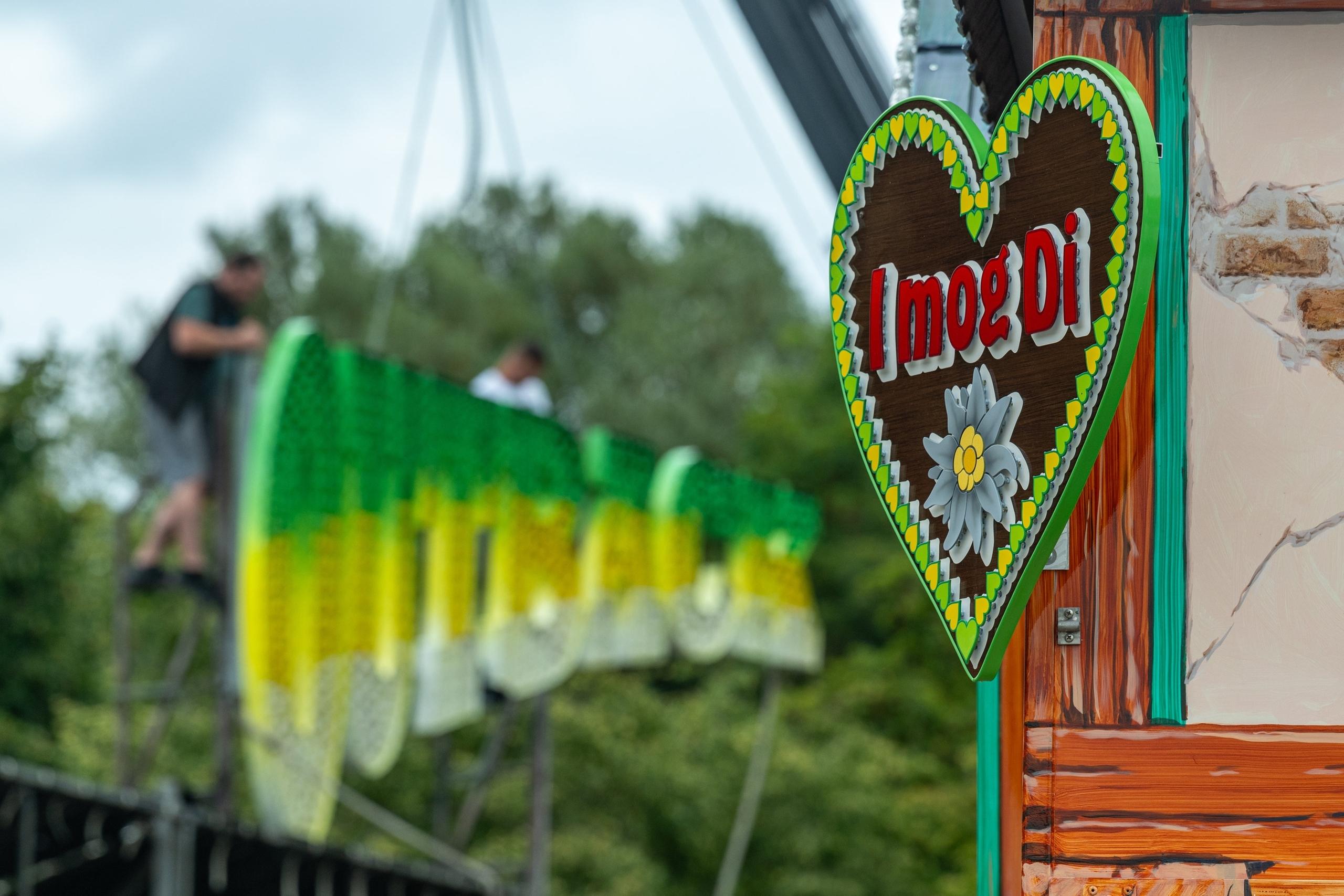 02.08.2024, Bayern, Straubing: ·«I mog Di·» steht auf einem Schild an einem Stand auf dem Gelände des Gäubodenvolksfestes. Die Arbeiten auf dem Festgelände der niederbayerischen Stadt schreiten voran. Das Volksfest dauert vom 9. bis 19. August. Foto: Armin Weigel/dpa +++ dpa-Bildfunk +++