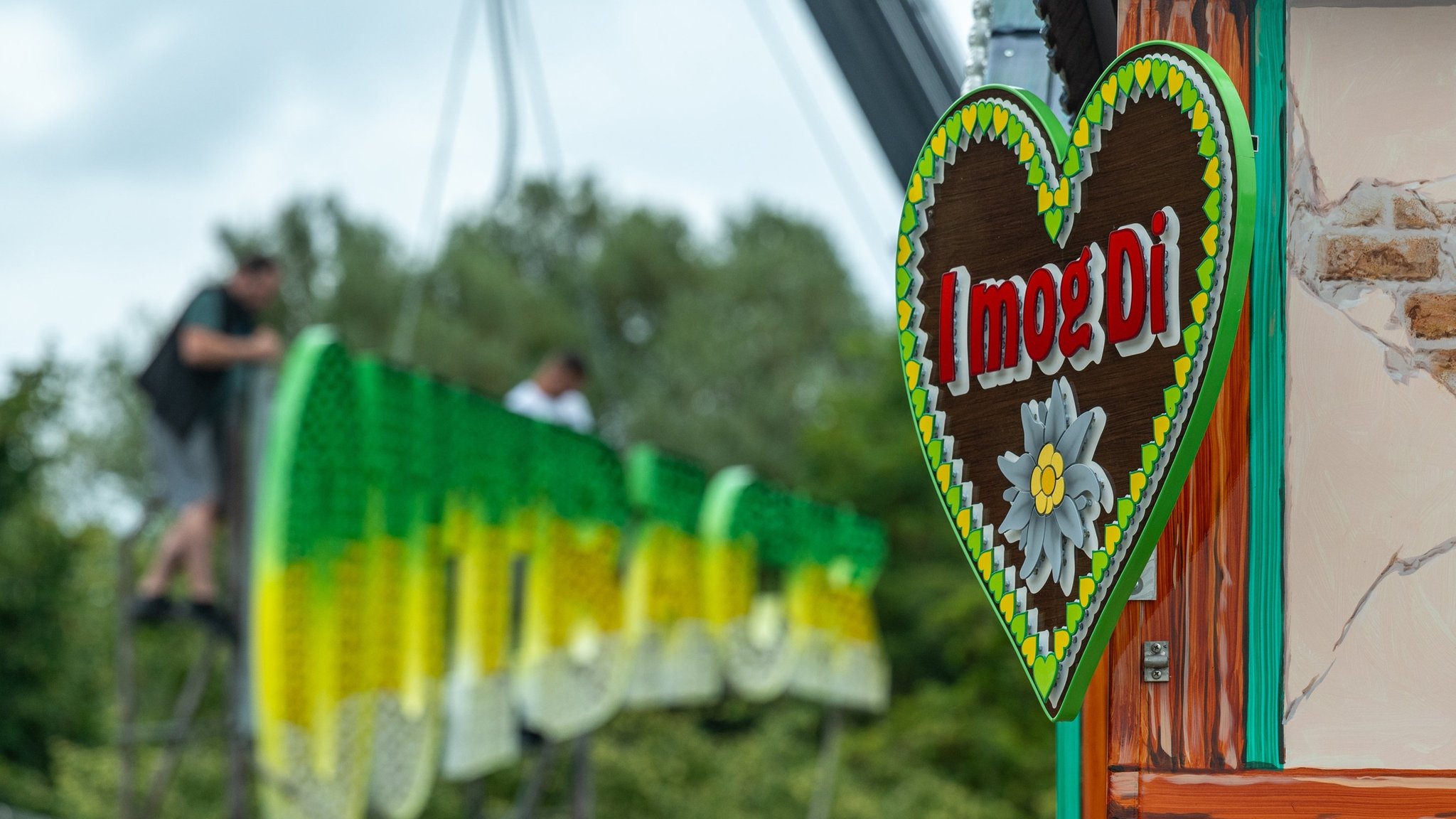 02.08.2024, Bayern, Straubing: ·«I mog Di·» steht auf einem Schild an einem Stand auf dem Gelände des Gäubodenvolksfestes. Die Arbeiten auf dem Festgelände der niederbayerischen Stadt schreiten voran. Das Volksfest dauert vom 9. bis 19. August. Foto: Armin Weigel/dpa +++ dpa-Bildfunk +++