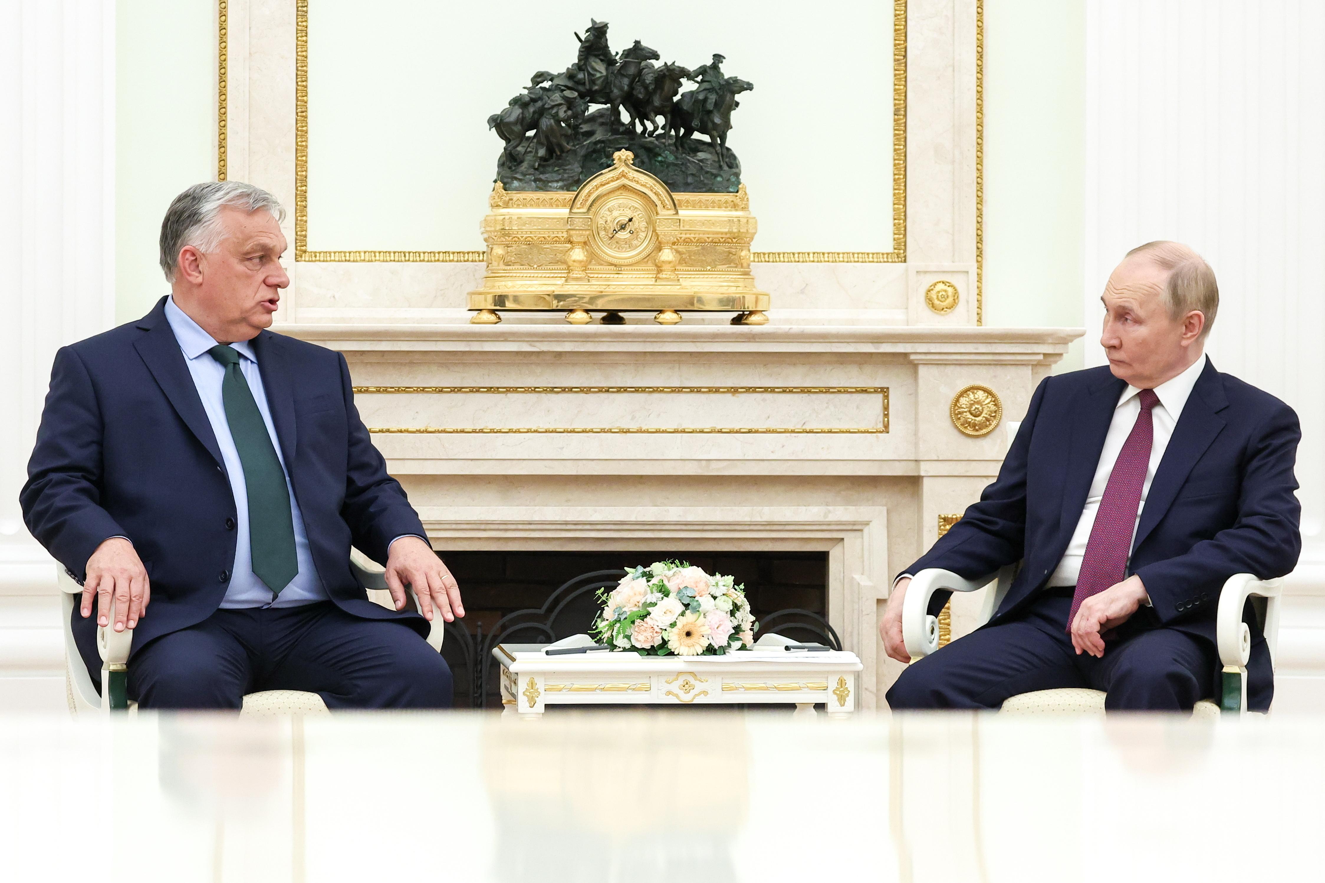 Die beiden Politiker sitzen an einem kleinen Tisch mit Blumen 