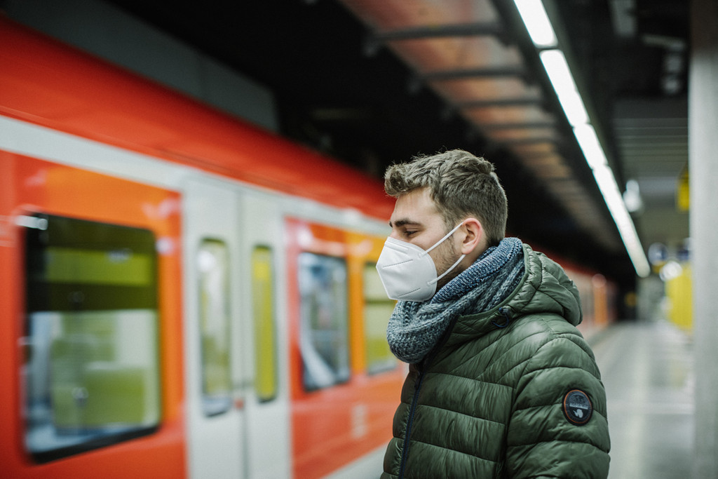 Ein Mann mit FFP2-Maske wartet am Bahnsteig auf die S-Bahn.