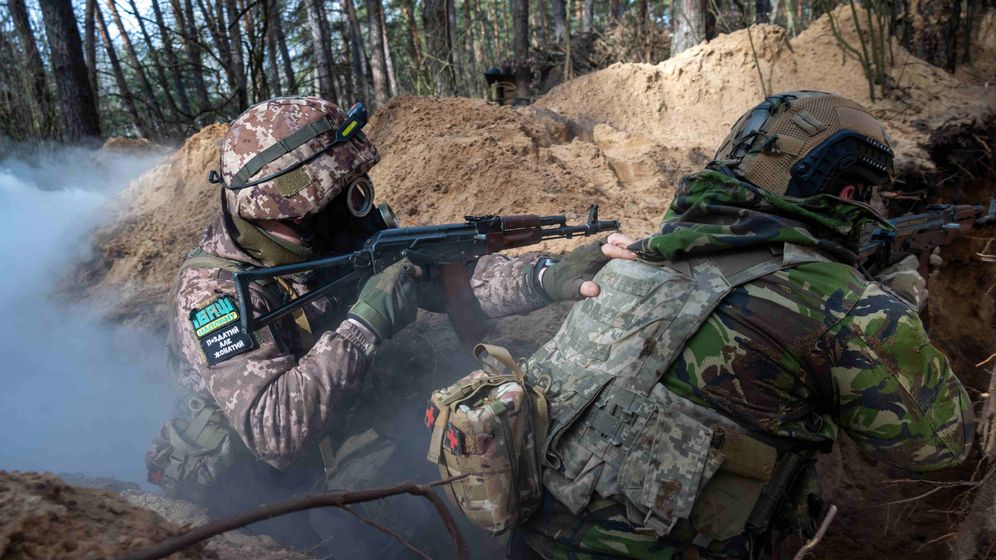 Symbolbild: Ukrainische Soldaten mit Maske beim Training im Schützengraben | Bild:picture alliance / Anadolu | Sergey Bobok