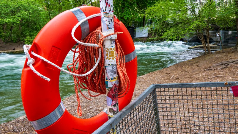 Ein Rettungsring hängt neben der künstlichen Welle am Münchner Eisbach. | Bild: dpa-Bildfunk/Peter Kneffel Ein Rettungsring hängt neben der künstlichen Welle am Münchner Eisbach.