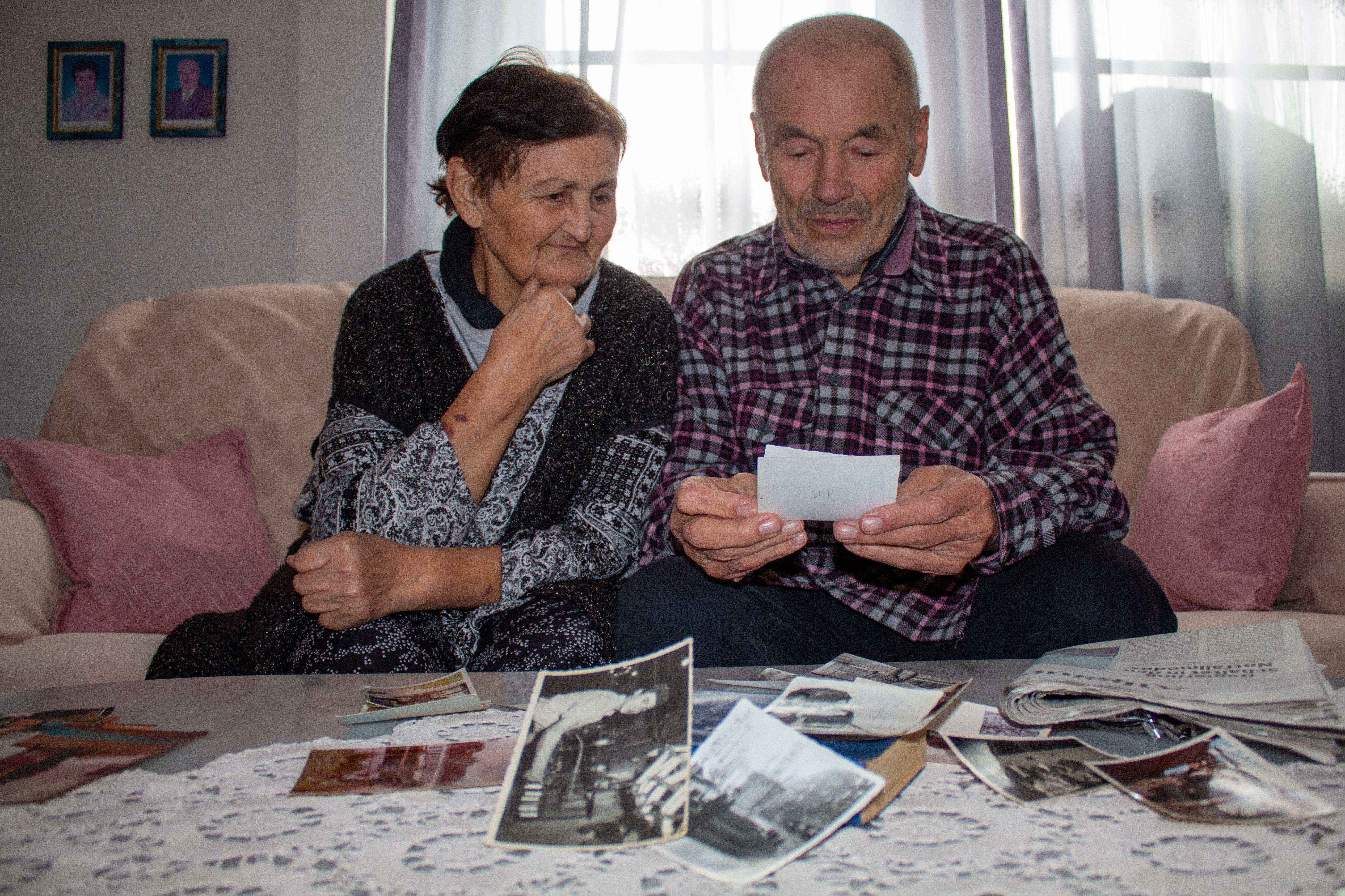 Dursun Düzer sitzt mit seiner Frau Sevim auf dem Sofa und schaut Fotos an