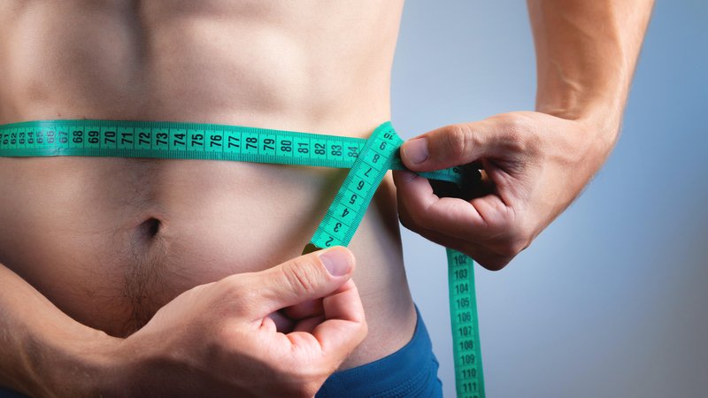 Man misst mit Maßband Bauchumfang | Bild: picture alliance / Zoonar | Ian Iankovskii Man misst mit Maßband Bauchumfang