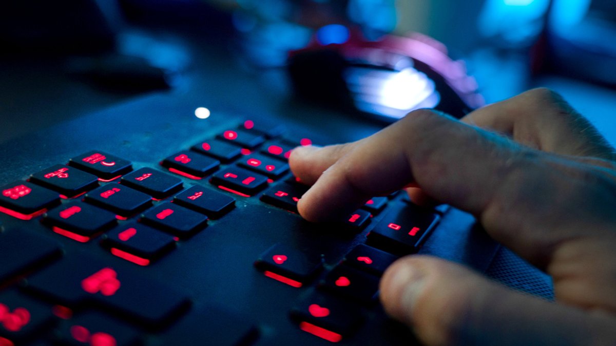 Mann sitzt am Rechner und tippt auf einer Tastatur. Kriminelle Hacker haben Unternehmen im Visier (Symbolbild)