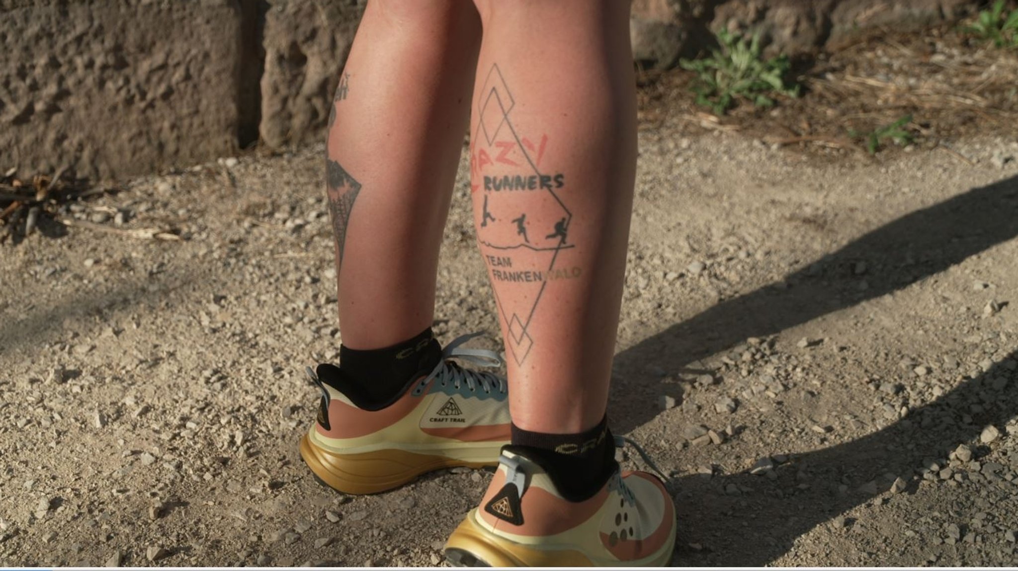 Das Logo und der Schriftzug des Crazy Runners Team Frankenwald als Tattoo auf einer Wade. 