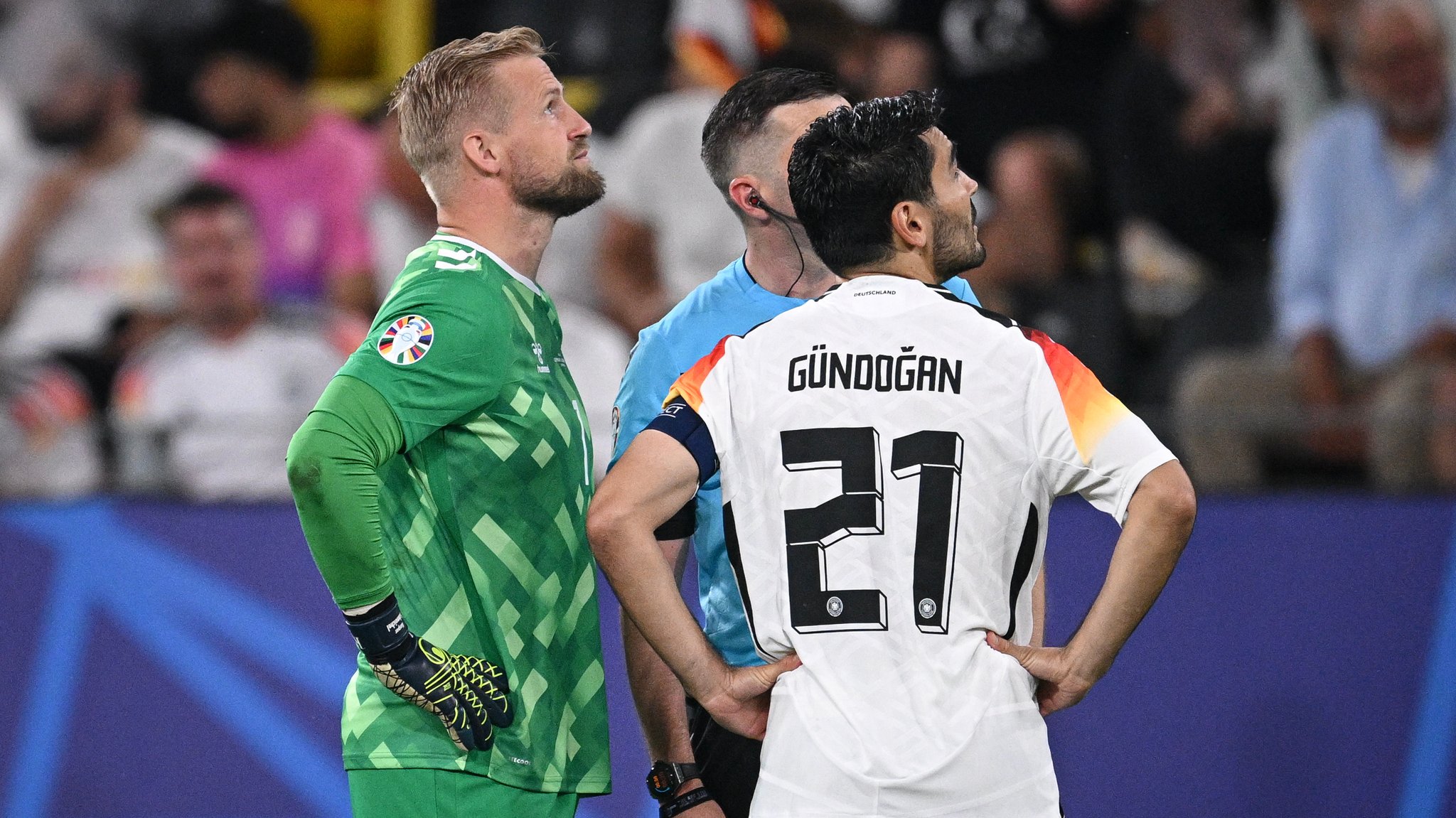 Schiedsrichter Michael Oliver holt  Ilkay Gündogan und Kasper Schmeichel zu sich.