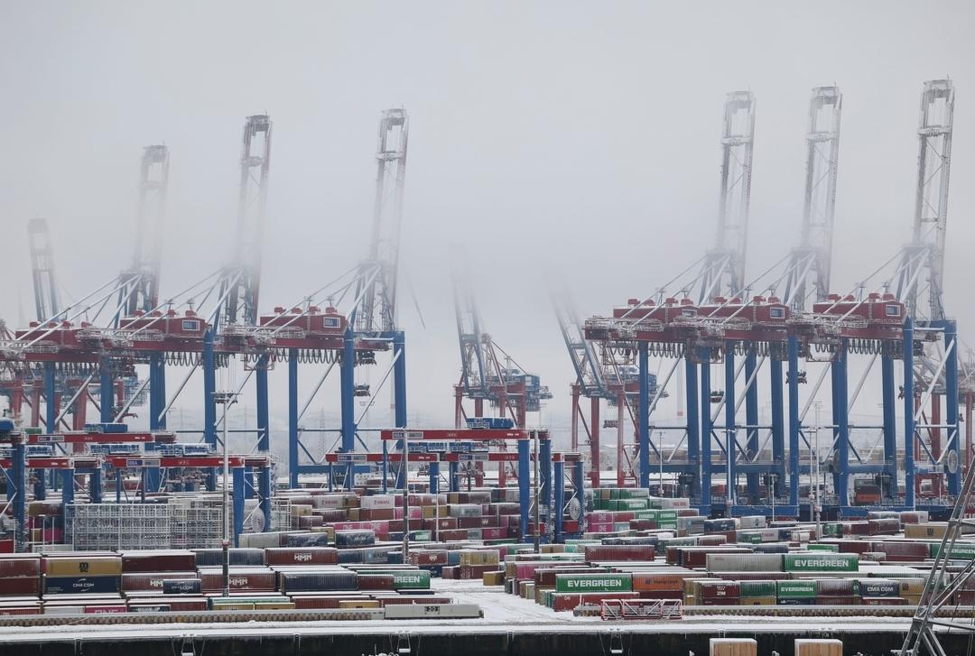 Hamburg: Die Container und Krananlagen am Terminal sind verschneit.