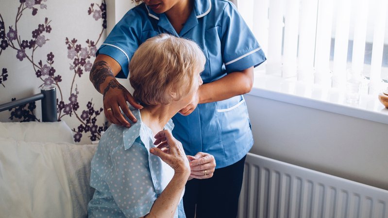 Eine Pflegekraft hilft einer Heimbewohnerin | Bild: dglimages/stock.adobe.com Eine Pflegekraft hilft einer Heimbewohnerin