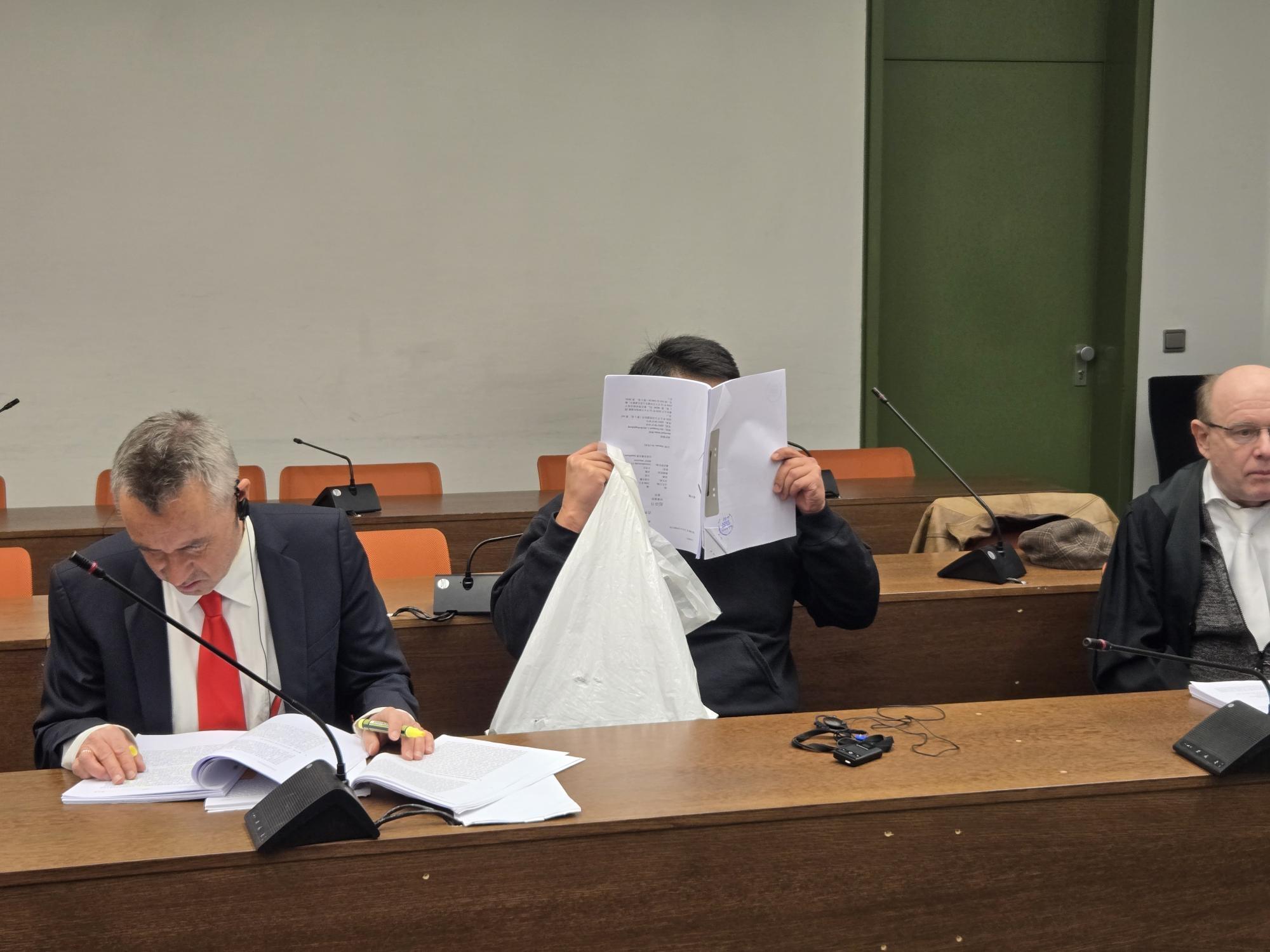 Der Angeklagte hinter Papieren