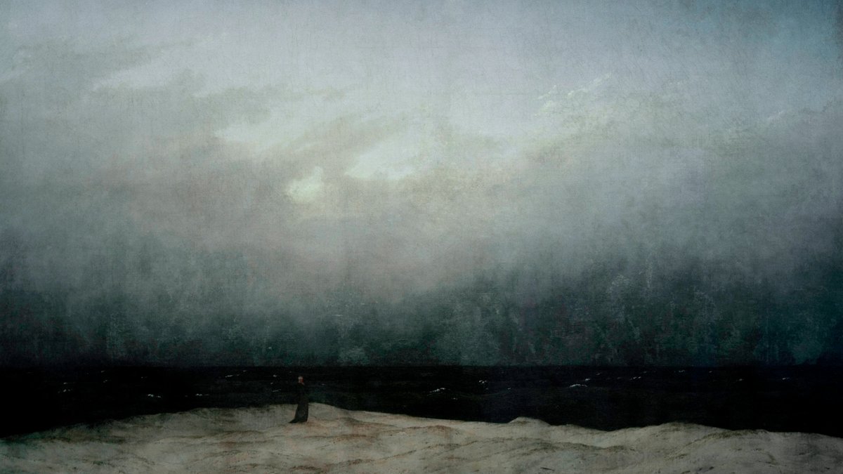 Einsamer Mann am Meer unter dunklem dräuenden Himmel
