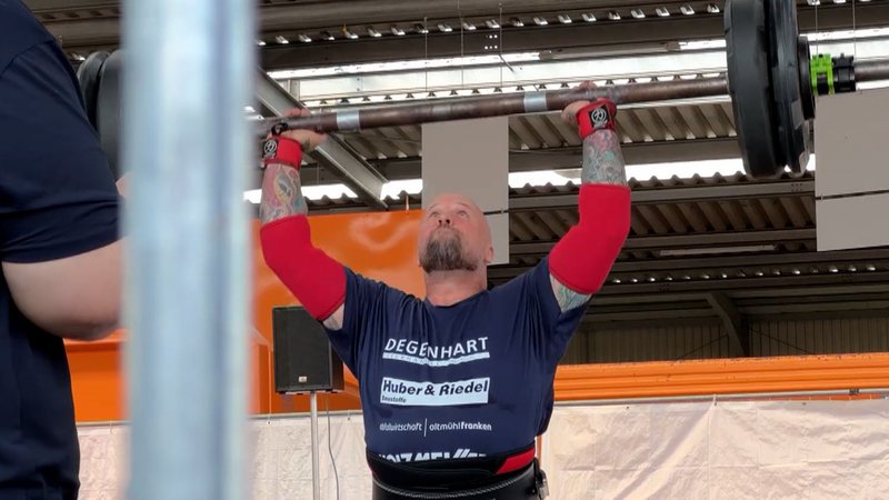 Ein Mann stämmt eine Langhantel über den Kopf. | Bild: BR Ein Mann stämmt eine Langhantel über den Kopf.