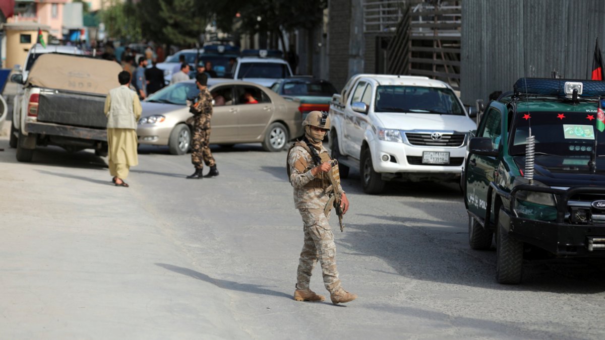 Afghanische bewaffnete Sicherheitskräfte gehen auf einer Straße unweit des Tatorts, an dem der Direktor des afghanischen Informationszentrums der Regierung Menapal erschossen wurde. 