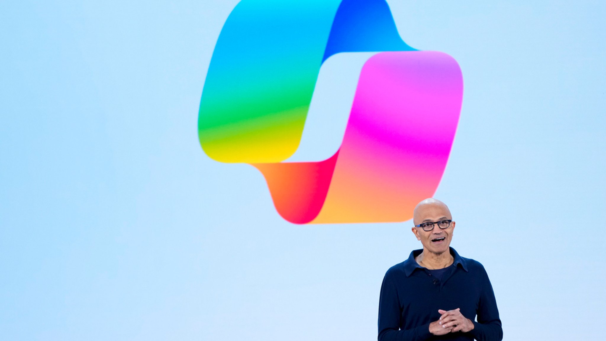 Microsoft-Chef Satya Nadella bei einer Rede. Im Hintergrund ist das Copilot-Logo zu sehen.