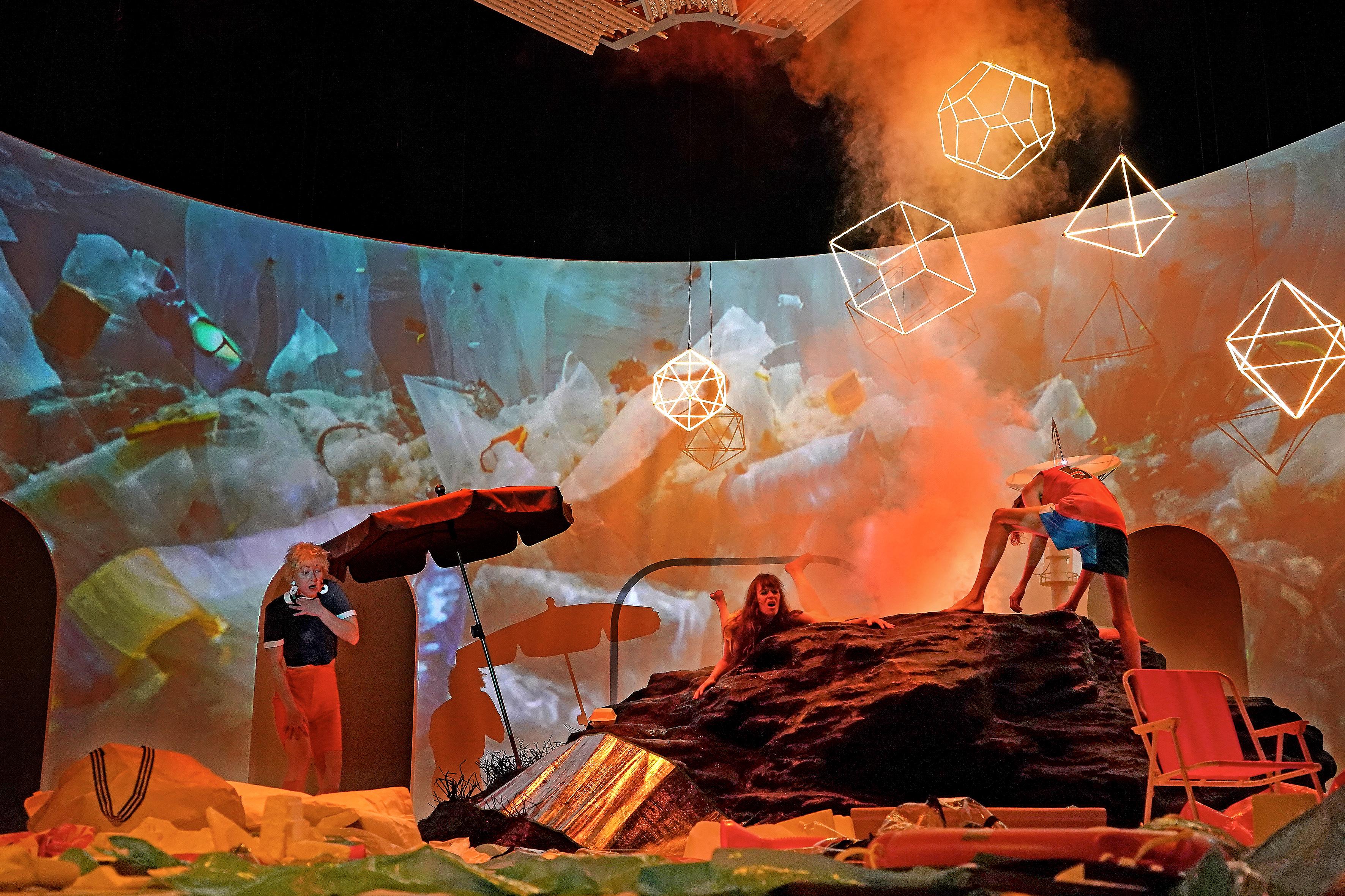 Ein verwüsteter Strand, drei erschrockene und verzweifelte Menschen: Strandurlaubsapokalypse: Svetlana Belesova, Katharina Bach, Bernardo Arias Porras in "Asche" von Elfriede Jelinek an den Münchner Kammerspielen