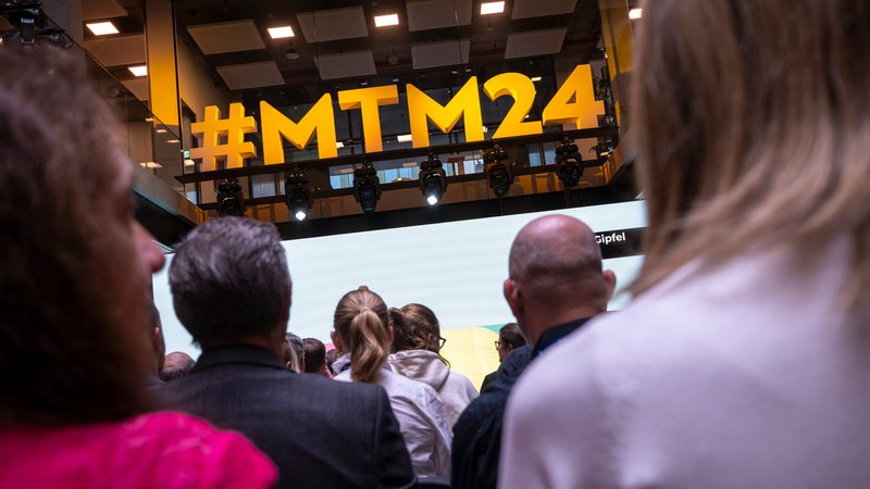 Der Hashtag #MTM24 ist bei den 38. Medientage München über den Köpfen der Teilnehmer zu sehen | Bild: dpa-Bildfunk/Peter Kneffel Der Hashtag #MTM24 ist bei den 38. Medientage München über den Köpfen der Teilnehmer zu sehen