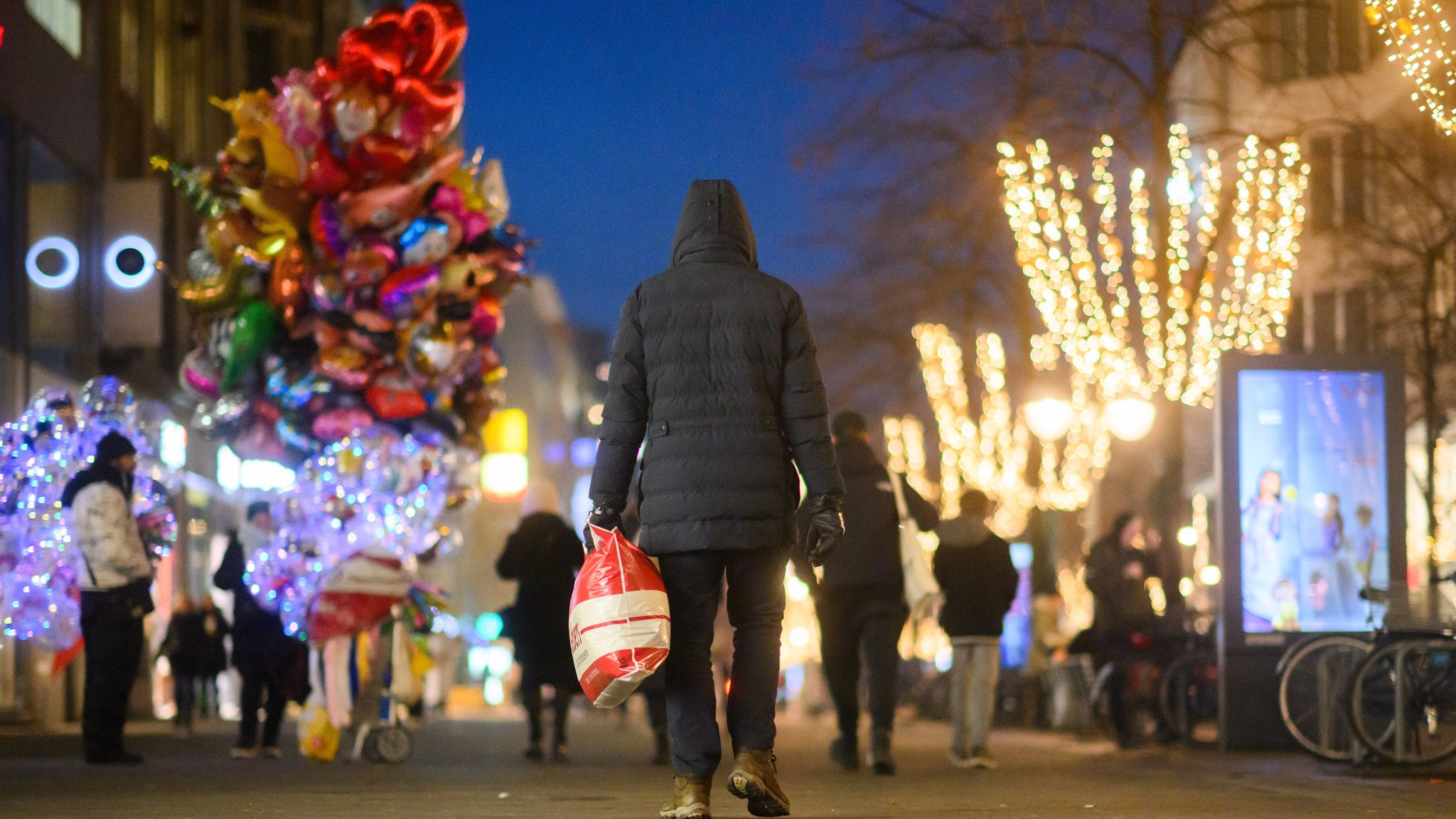 Passant läuft mit Taschen durch eine Einkaufsstraße