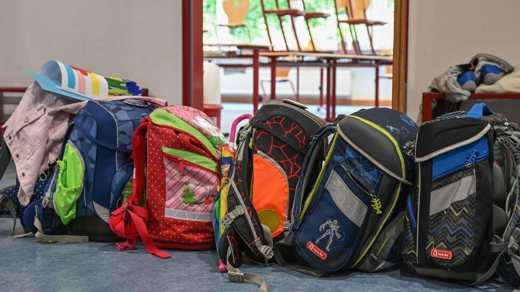 Schulranzen stehen vor einem Klassenzimmer. (Symbolbild)