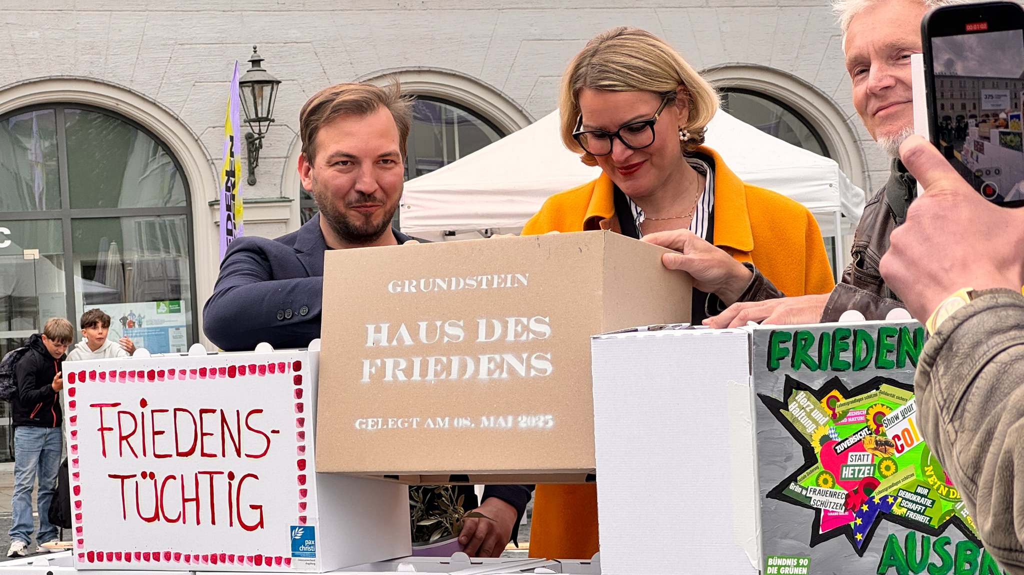 v.l.n.r.: Der Künstlerische Leiter des Kulturprogramms des Friedensfestes Eric Nikodym, Augsburgs Oberbürgermeisterin Eva Weber und der Künstler Frank Bölter | Bild: BR/René Kirsch v.l.n.r.: Der Künstlerische Leiter des Kulturprogramms des Friedensfestes Eric Nikodym, Augsburgs Oberbürgermeisterin Eva Weber und der Künstler Frank Bölter