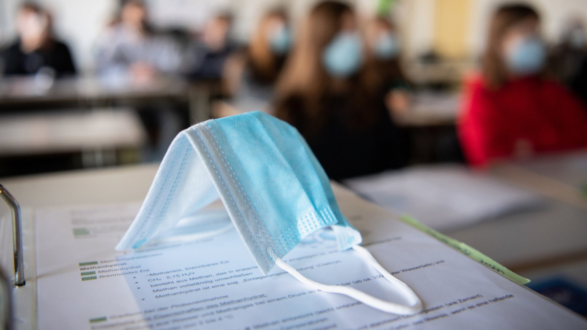 Eine Maske liegt in einem Klassenzimmer