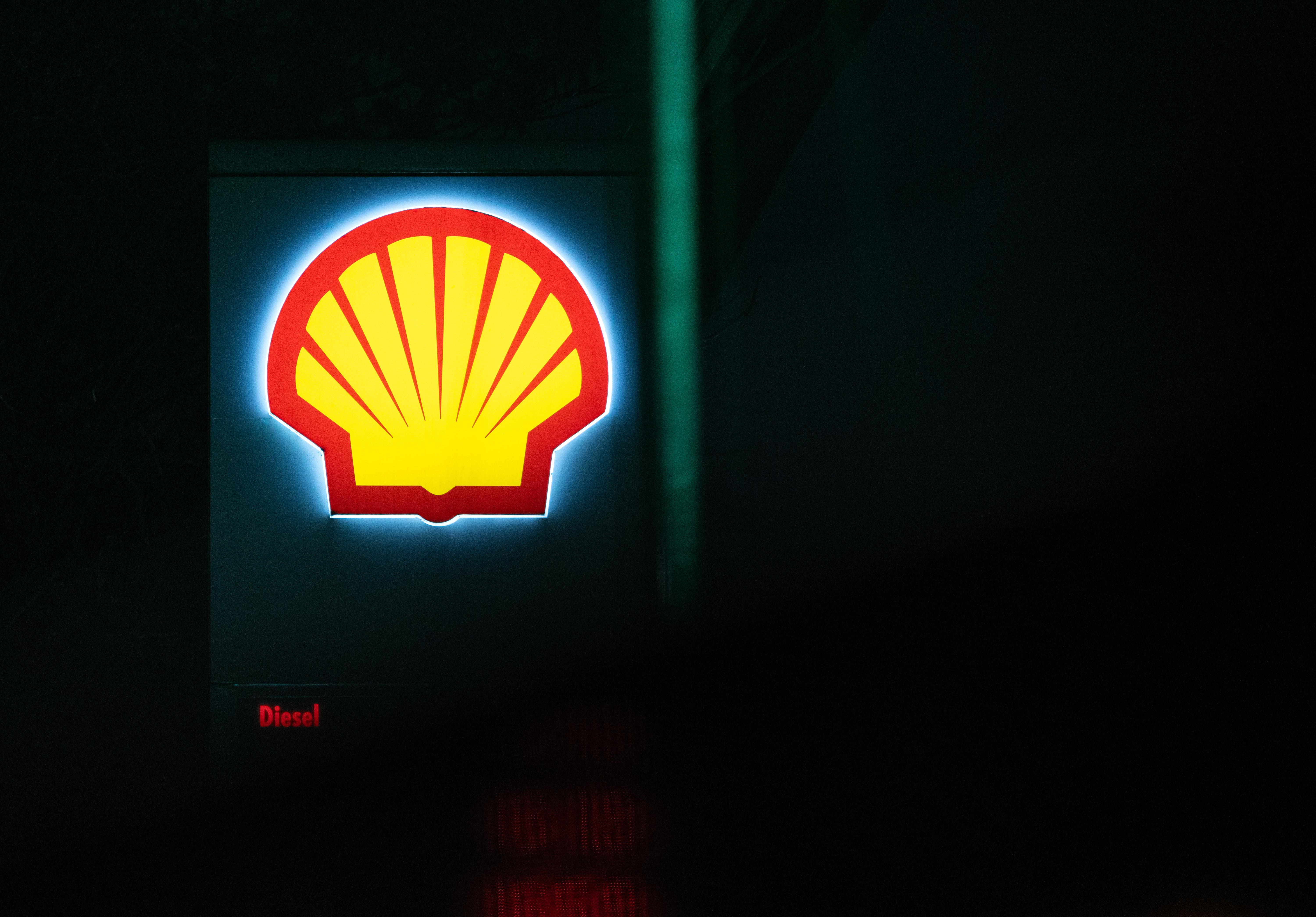 Ein Shell-Logo einer Tankstelle leuchtet im Dunkeln in Berlin.