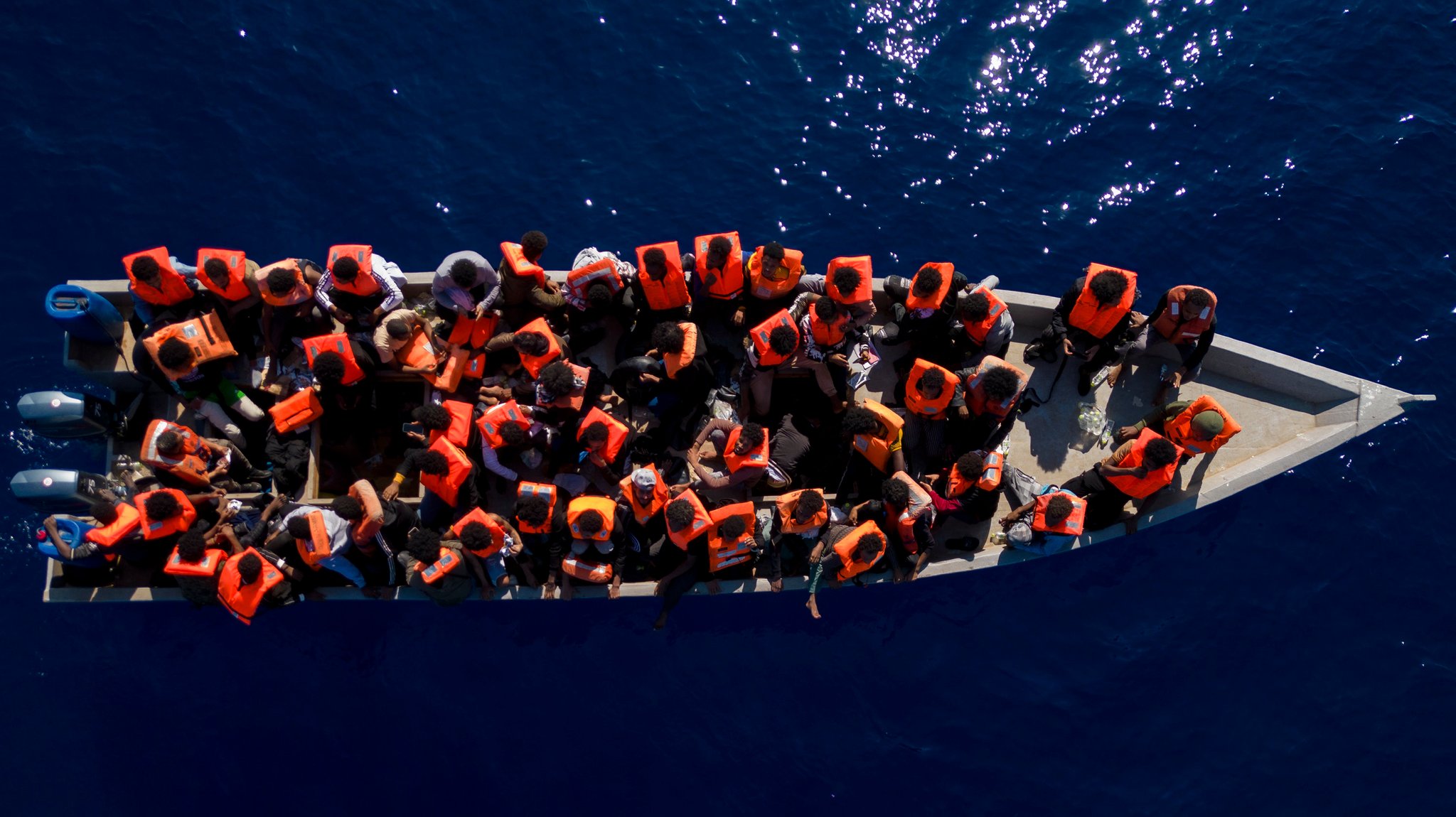 Geflüchtete auf einem Boot im Meer (Symbol- und Archivbild)