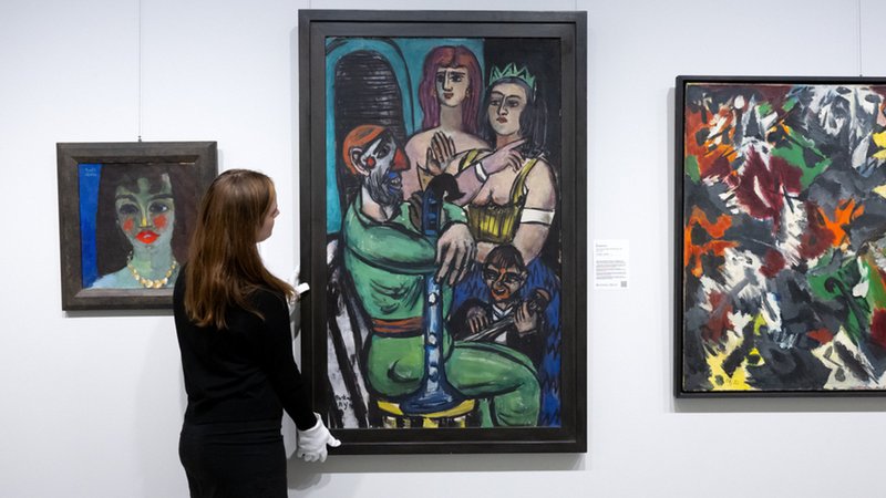 04.12.2024, Bayern, München: Die Bilder "Vera" (l-r) von Emil Nolde, "Großer Clown mit Frauen und kleiner Clown" von Max Beckmann und "Von Höhlen und Grotten" von Ernst Wilhelm Nay sind bei einer Vorbesichtigung im Auktionshaus Ketterer Kunst zu sehen. | Bild: dpa-Bildfunk/Sven Hoppe 04.12.2024, Bayern, München: Die Bilder "Vera" (l-r) von Emil Nolde, "Großer Clown mit Frauen und kleiner Clown" von Max Beckmann und "Von Höhlen und Grotten" von Ernst Wilhelm Nay sind bei einer Vorbesichtigung im Auktionshaus Ketterer Kunst zu sehen.