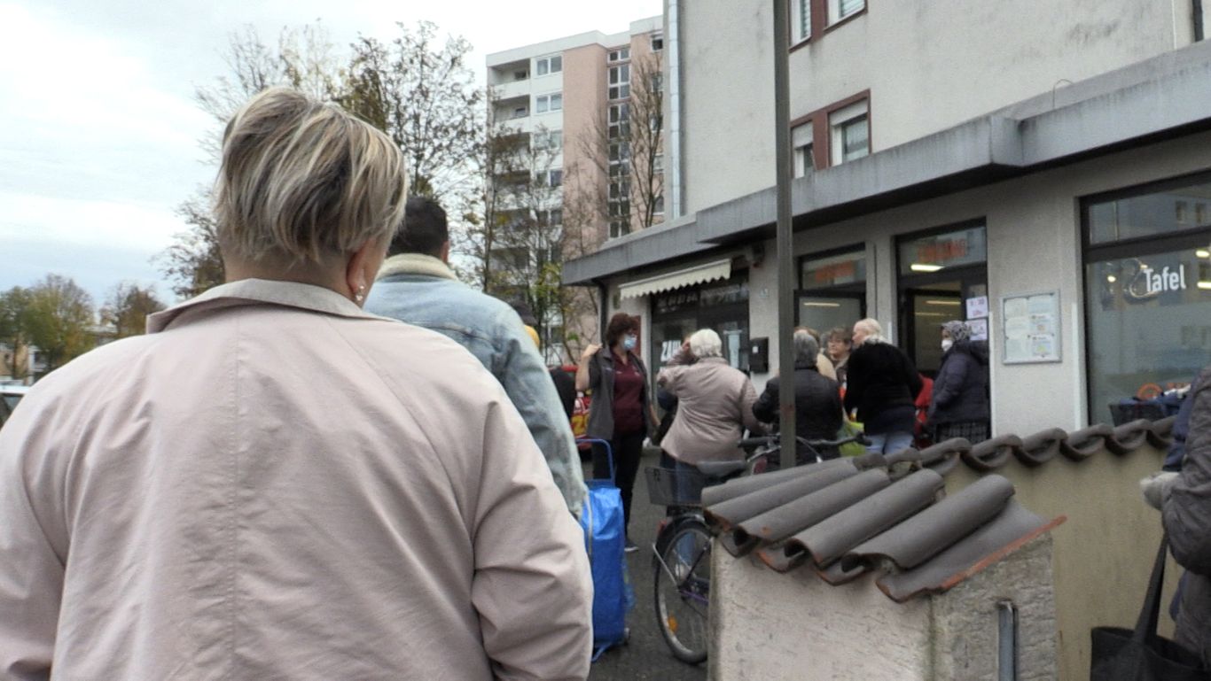 Menschenschlange vor Tafelladen. 