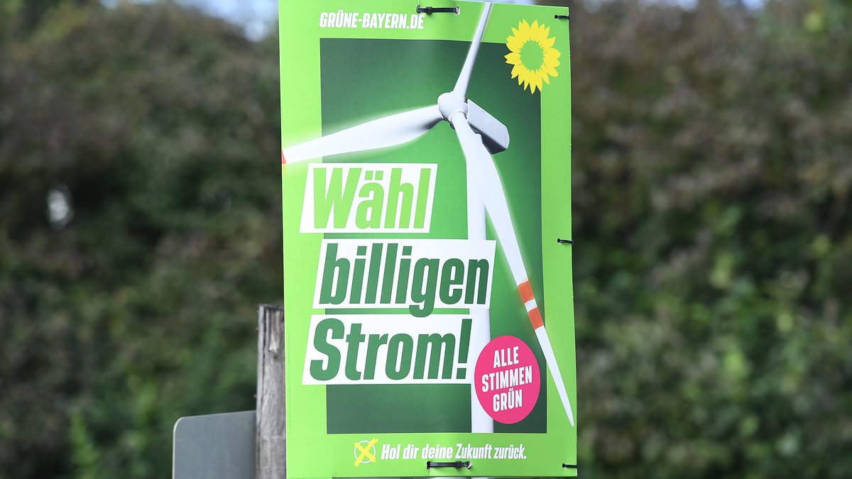 Ein Wahlplakat der Grünen aus dem bayerischen Landtagswahlkampf mit dem Slogan" Wähl billigen Strom" und einem Windrad.