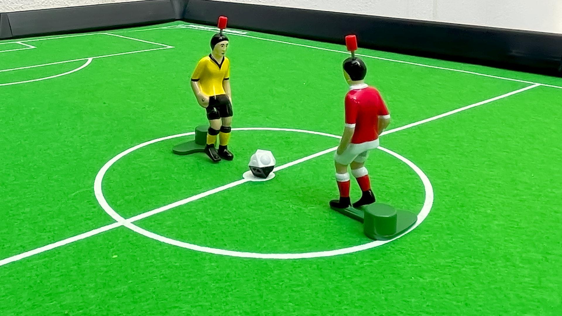 Zwei Tipp-Kick-Figuren auf dem grünen Spielrasen.