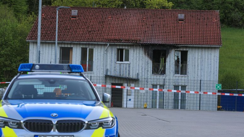 Ein Polizeiwagen steht vor einer Asylbewerberunterkunft, in der ein Feuer ausgebrochen war. | Bild:News5 / Merzbach
