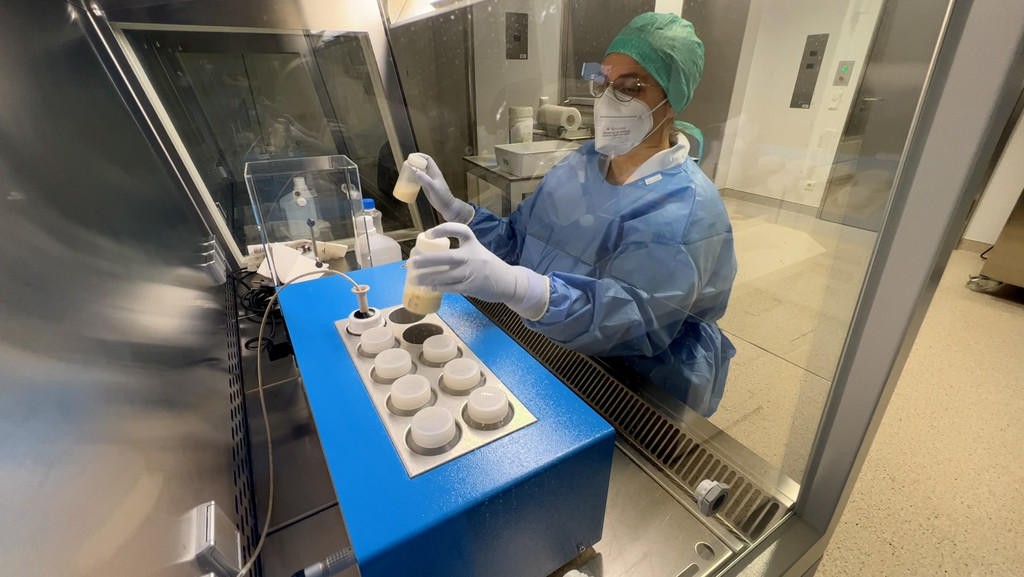 Eine Mitarbeiterin stellt Fläschchen mit gespendeter Muttermilch in einen Pasteurisator