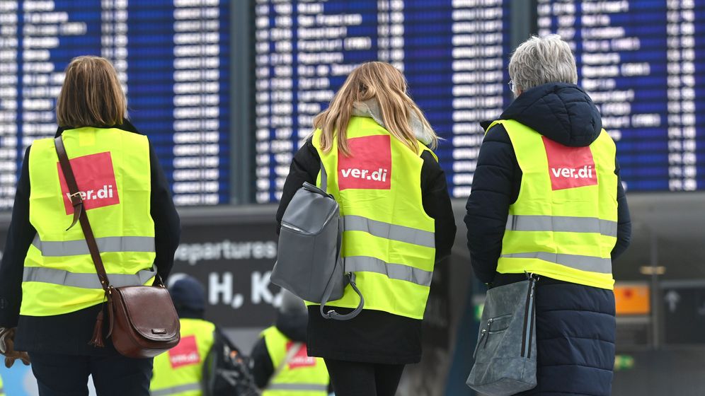 Drei Streikende in Verdi-Warnwesten am Flughafen München | Bild:picture alliance / SvenSimon | Frank Hoermann/SVEN SIMON
