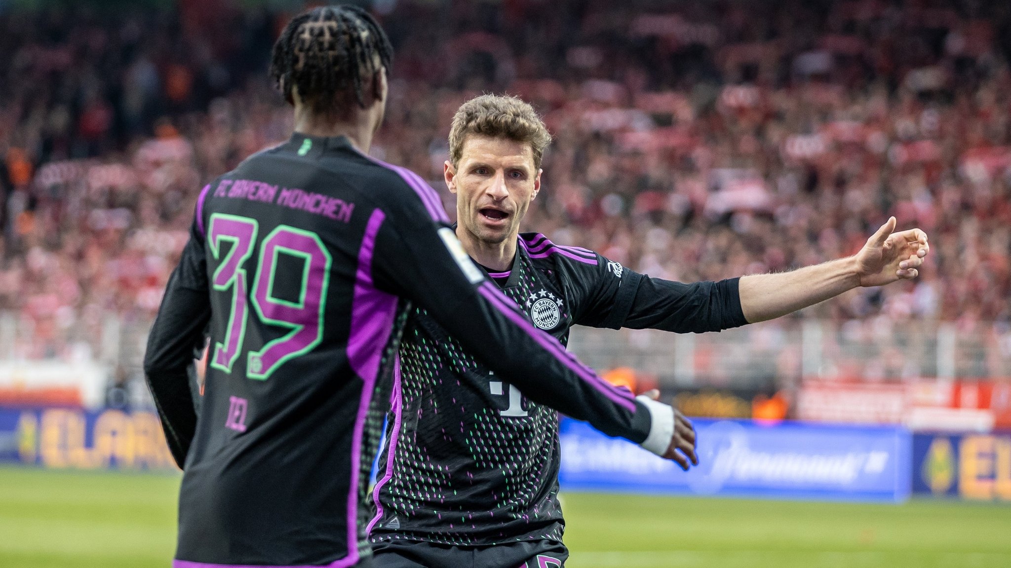 20.04.2024, Berlin: Fußball: Bundesliga, 1. FC Union Berlin - Bayern München, 30. Spieltag, An der Alten Försterei. Mathys Tel von Bayern München jubelt nach seinem 4:0 Treffer mit Teamkollege Thomas Müller (r). Foto: Andreas Gora/dpa - WICHTIGER HINWEIS: Gemäß den Vorgaben der DFL Deutsche Fußball Liga bzw. des DFB Deutscher Fußball-Bund ist es untersagt, in dem Stadion und/oder vom Spiel angefertigte Fotoaufnahmen in Form von Sequenzbildern und/oder videoähnlichen Fotostrecken zu verwerten bzw. verwerten zu lassen. +++ dpa-Bildfunk +++