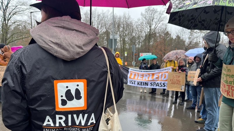 Demonstranten im Regen mit Plakaten und Transparenten