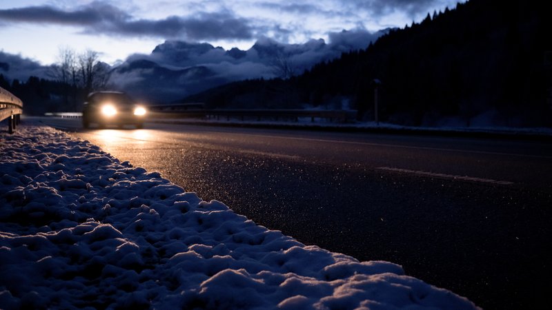 Ein Auto fährt über eine Straße, während die umliegende Landschaft schneebedeckt ist | Bild: picture alliance/dpa | Sven Hoppe Ein Auto fährt über eine Straße, während die umliegende Landschaft schneebedeckt ist