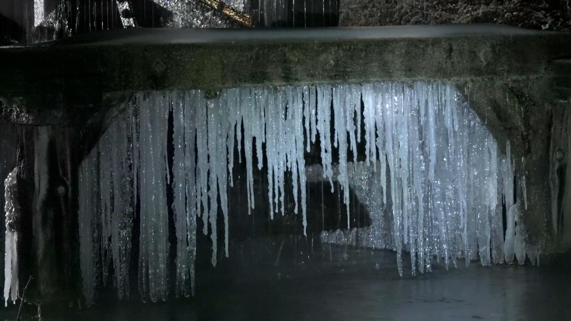 Eiszapfen hängen von einer Dachrinne