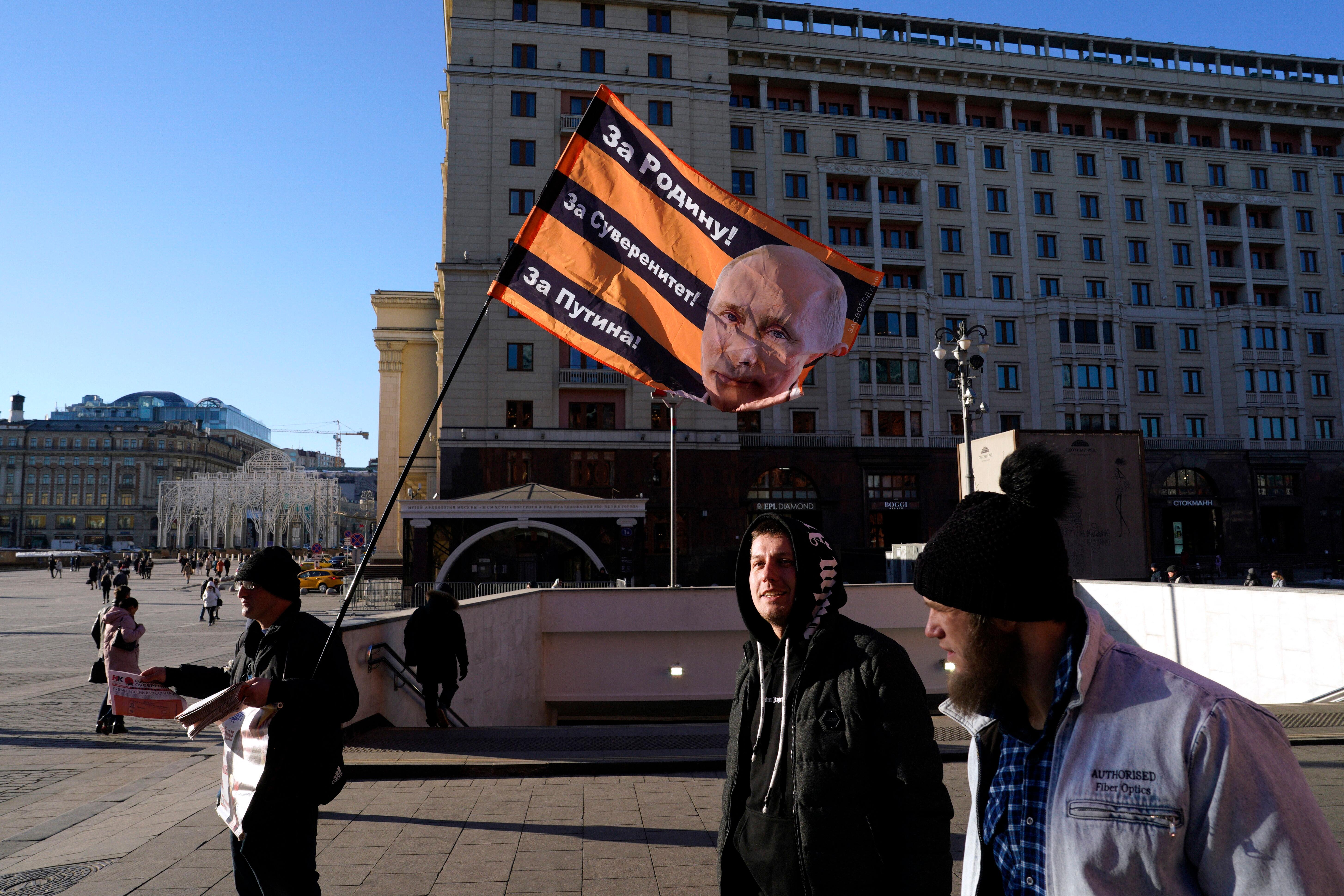 Im "Wahlkampf" trägt ein Passant Werbebanner durch die Stadt