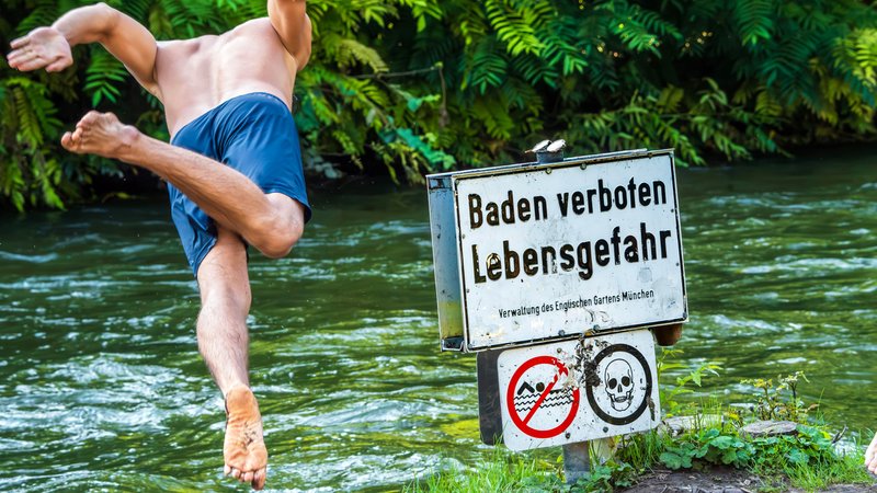 Baden verboten - Mann springt in den Eisbach. Daneben ein Schild mit der Aufschrift "Baden verboten Lebensgefahr" | Bild: picture alliance / Wolfgang Maria Weber | R7172 Baden verboten - Mann springt in den Eisbach. Daneben ein Schild mit der Aufschrift "Baden verboten Lebensgefahr"