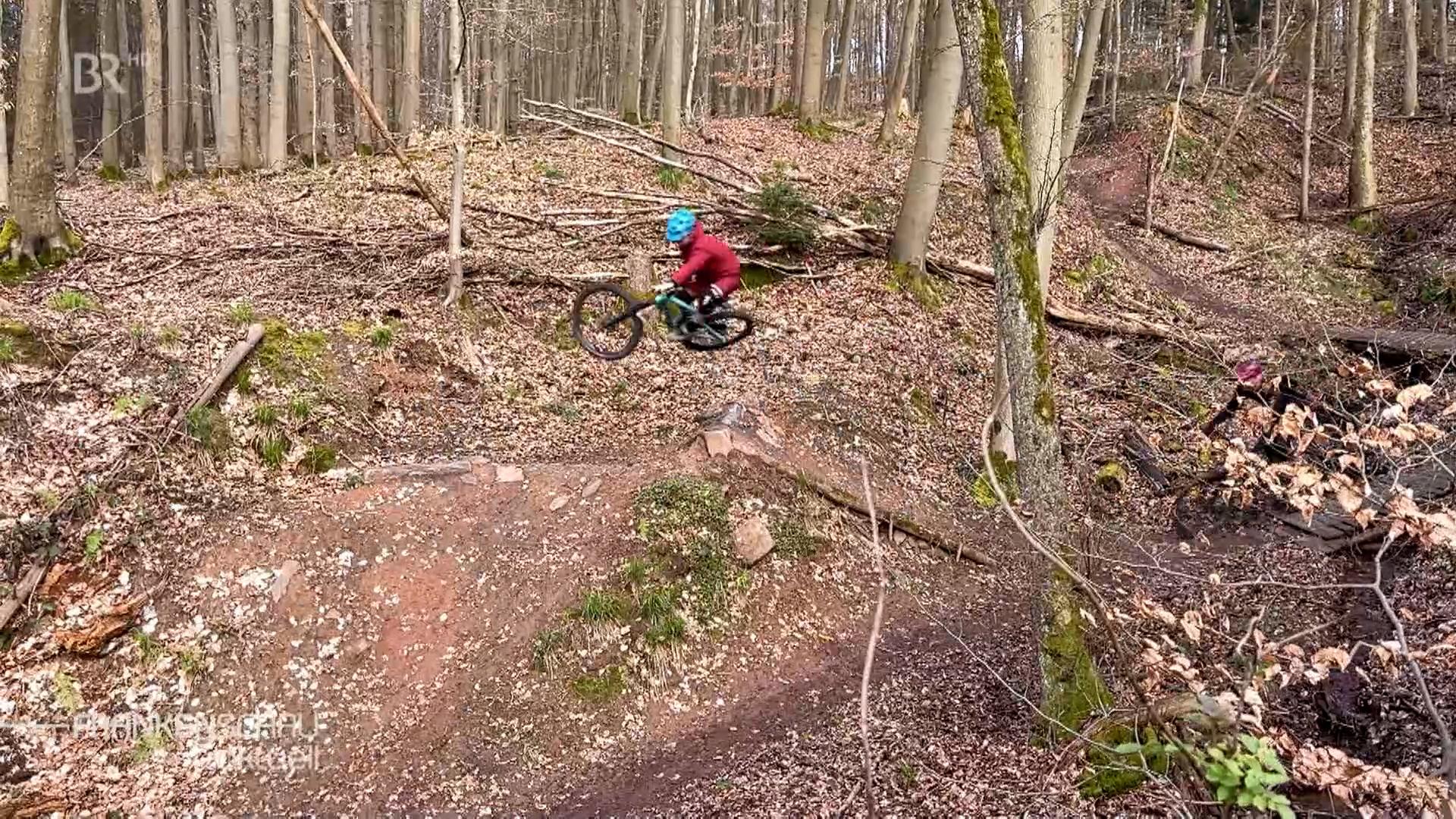Mountainbiker mit Rad in der Luft.