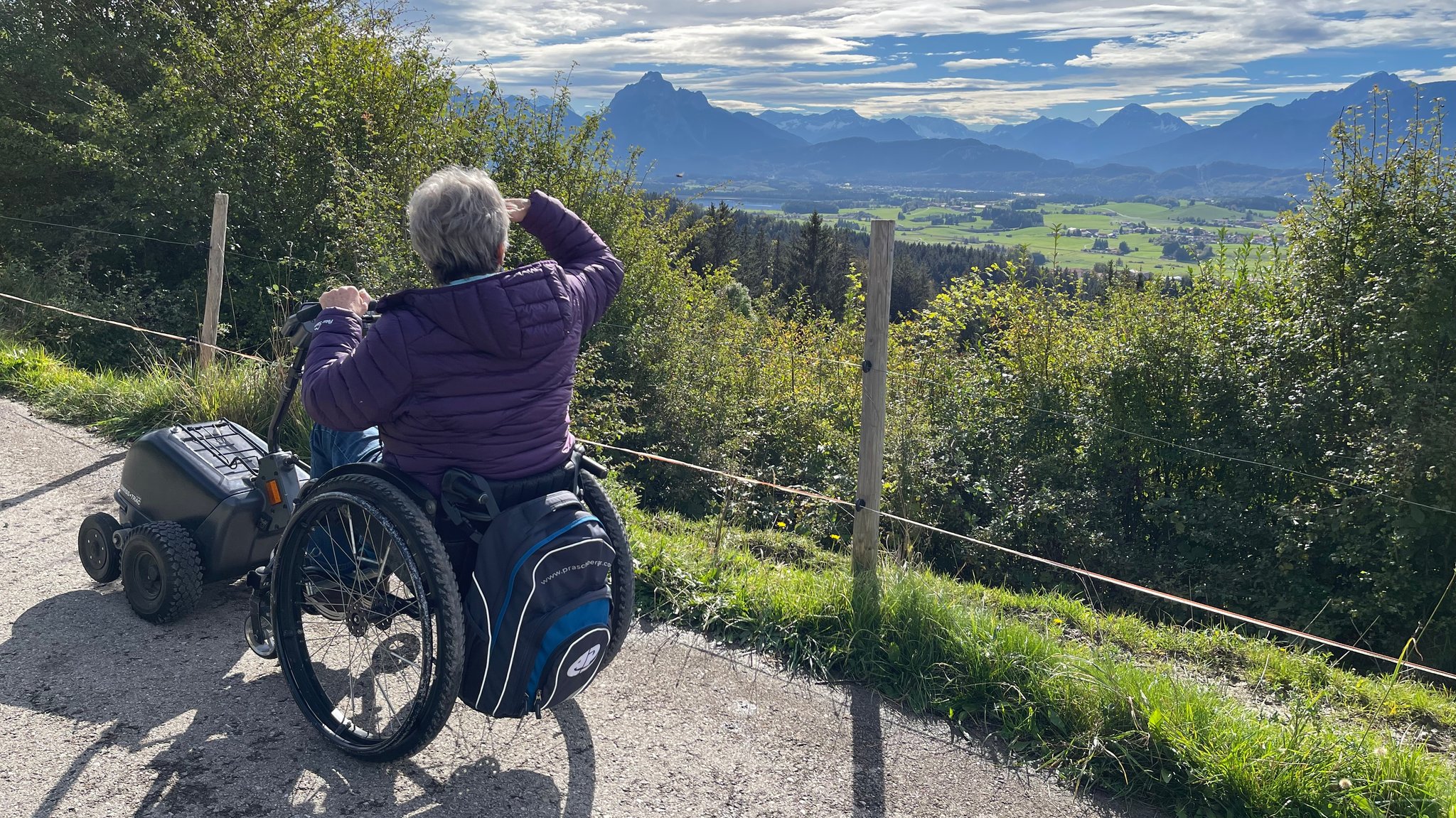 Gerda Pamler blickt Richtung Ostallgäuer Berge, in der Ferne ragt der Säuling auf.