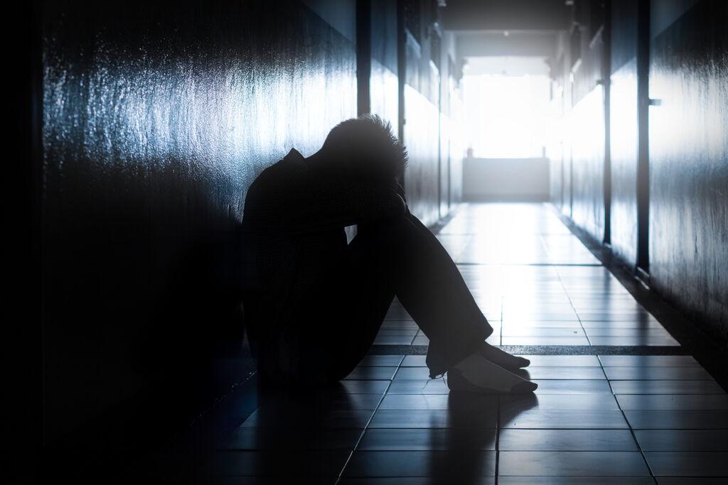 Ein unglücklicher Mensch sitzt in einem Gang. (Symbolfoto)