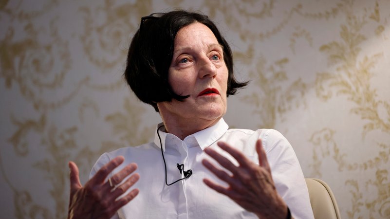 Die Schriftstellerin Herta Müller in weißem Hemd und mit schwarzen Haaren gestikuliert mit den Händen
