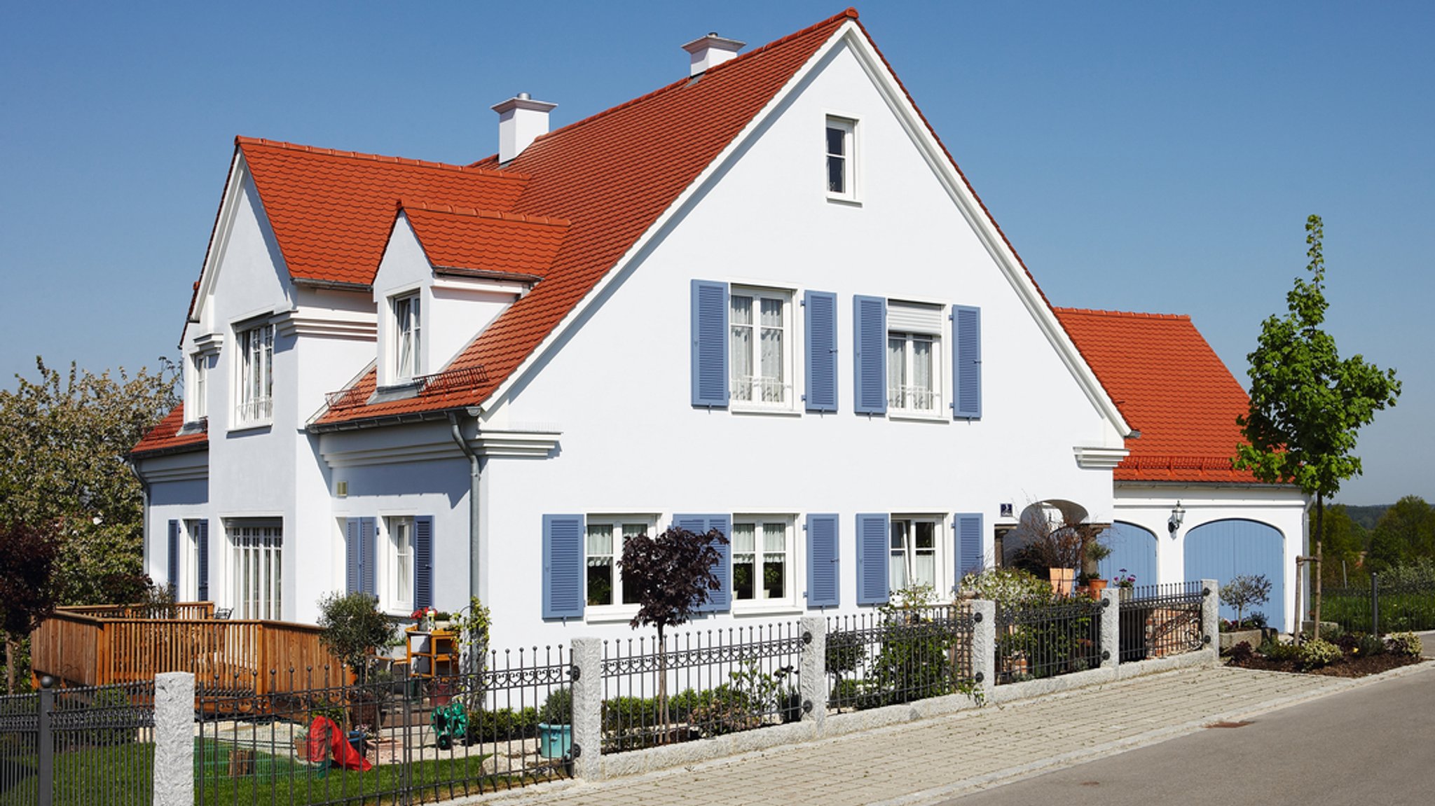 Ein Einfamilienhaus mit Garten und Garage.