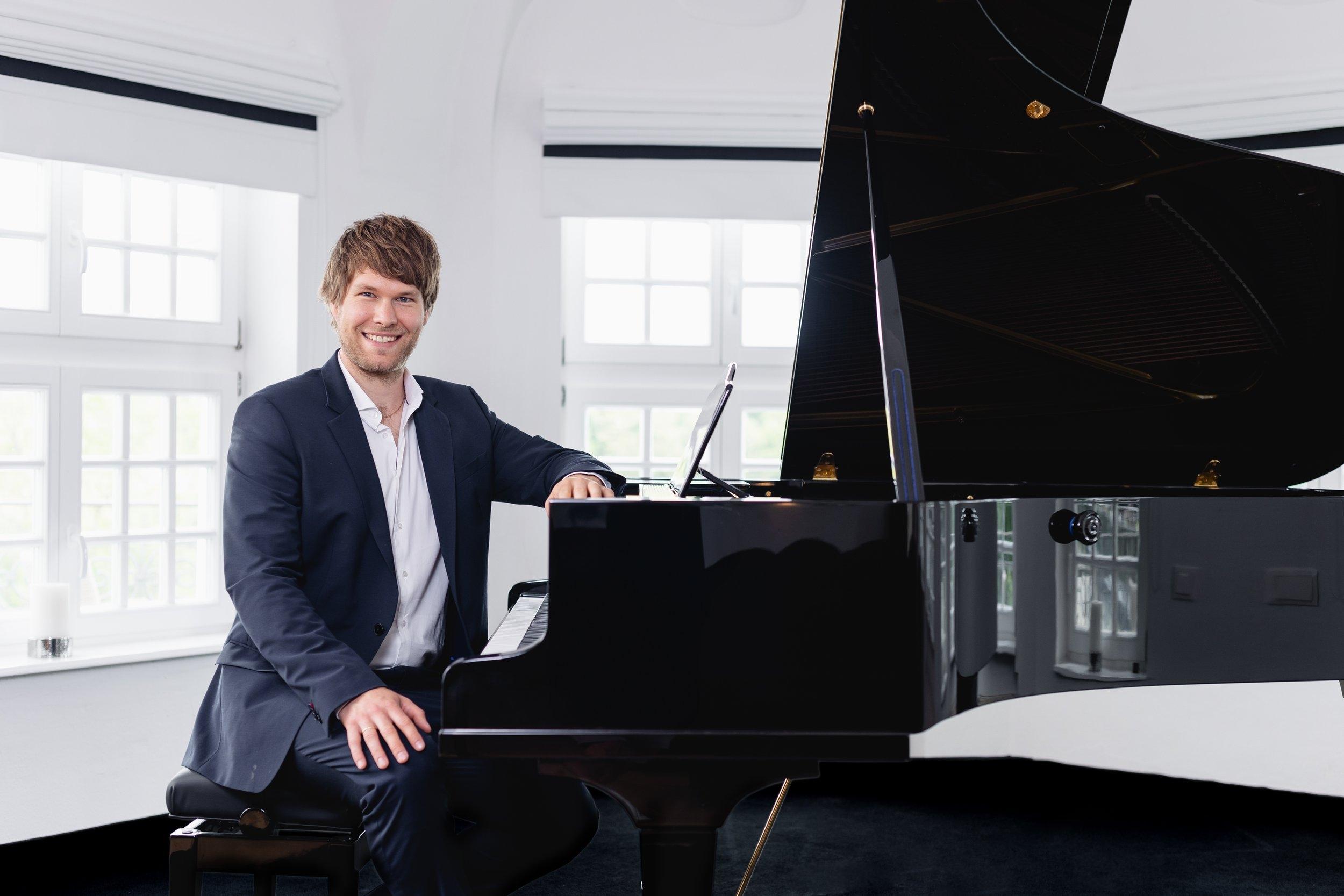 Der Komponist in schwarzem Anzug mit weißem Hemd