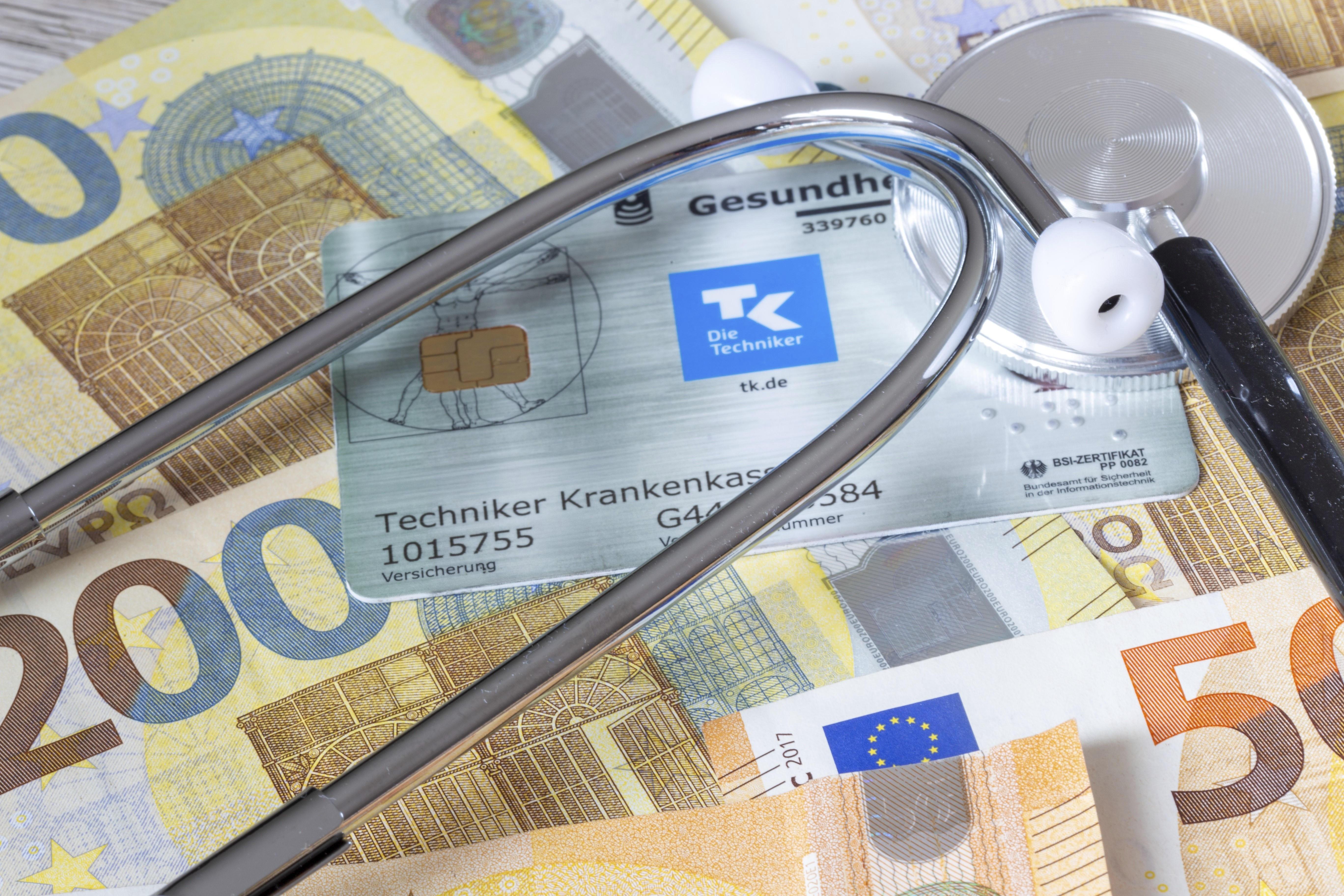 Krankenversicherung Symbolbild: Krankenkarte, Stethoskop und Bargeld