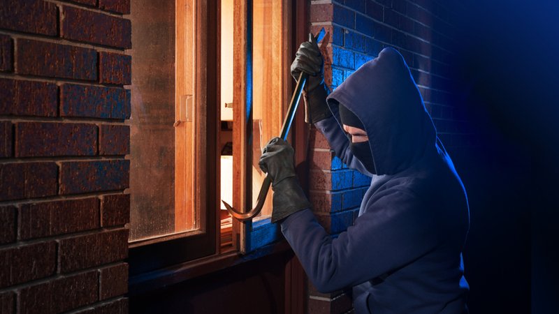 Ein Einbrecher hebelt ein Fenster auf. | Bild: stock.adobe.com/Christian Delbert Ein Einbrecher hebelt ein Fenster auf.
