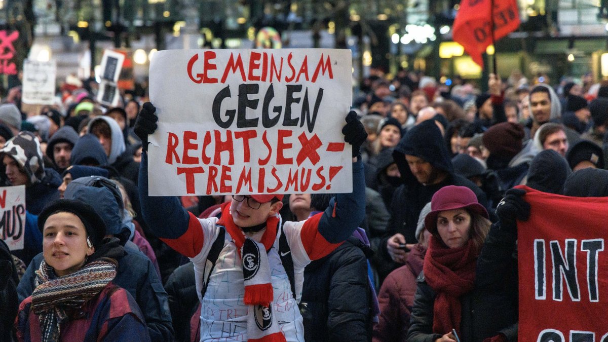 Ein Teilnehmer einer Demo gegen die AFD und Rechtsextremisms hält ein Plakat mit der Aufschrift "Gemeinsam gegen Rechtsextremismus"