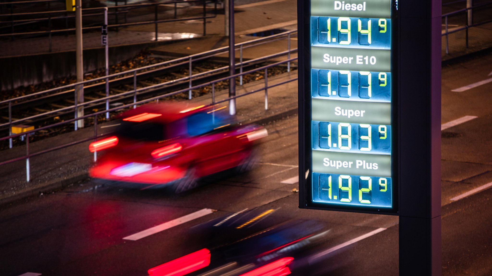 Archivbild: Autos fahren an einer Preistafel einer Tankstelle vorbei.